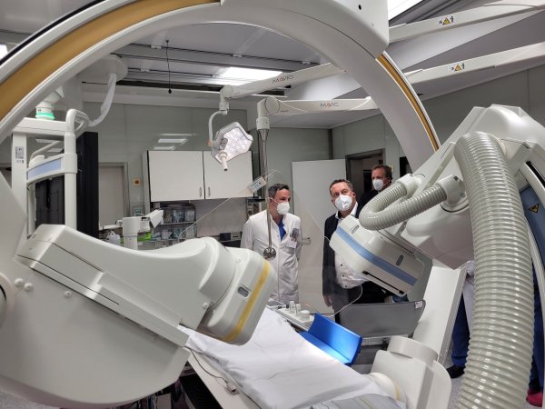 Dr. Marois Vlachojannis zeigt Landrat Dr. Axel Lehmann die neue Technik im Herzkatheterlabor. Im Vordergrund sieht man die beweglichen bildgebenden Köpfe. Im Hintergrund steht Dr. Johannes Hütte. - © Astrid Sewing