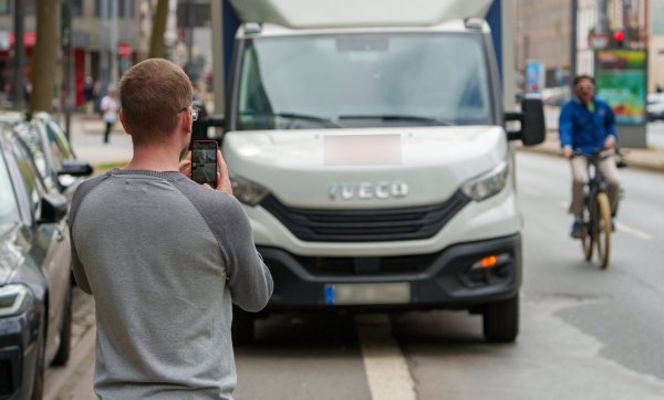 Ein Lieferwagen steht auf dem Radweg. Das ist nicht erlaubt. Ein Mann macht von dem Verstoß ein Foto, um es später zur Anzeige zu bringen. - © Andreas Arnold