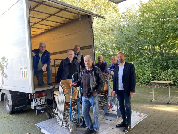 Mehrere hundert Stühle und Tische finden eine neue Bestimmung: Bernd Hendig, Schulleiter der Karla-Raveh-Gesamtschule (rechts) freut sich mit Friedhold Stock, Jürgen Wattenberg, Hubertus Sprick, Herbert Büsching, Georg Nork und Horst Jüngling (von links), dass die Möbel in Litauen wieder zum Einsatz kommen. - © Kreis Lippe