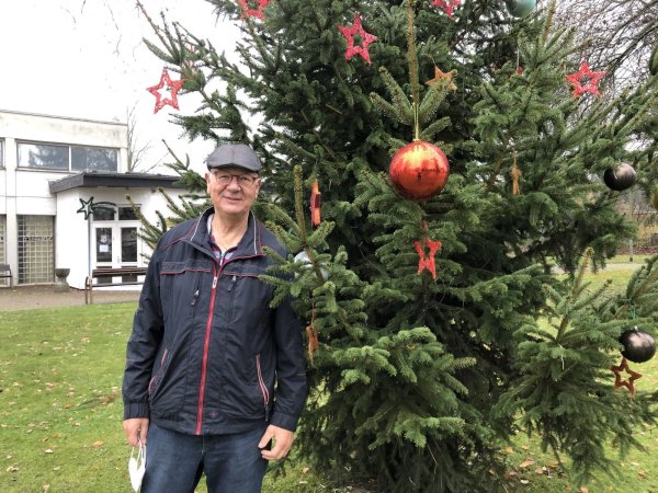 Hans Carell steht am geschmückten Weihnachtsbaum in der Ortsmitte von Wülfer-Bexten. Auch diesen Weihnachtsgruß würde es ohne den Bürgerverein nicht geben. - © Thomas Reineke