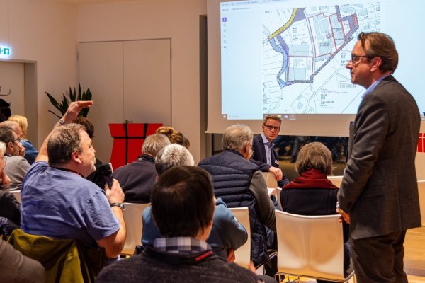 Die geschäftsführenden Gesellschafter Alexander Weber (rechts) und Ralph Schomburg (hinten) stellen sich bei der Bürgerversammlung den Fragen der Anwohner. - © Raphael Bartling