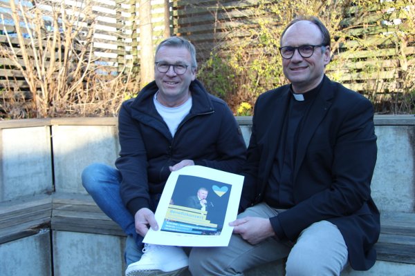 Ingo Dickewied (links) und Andreas Lange halten das Werbeplakat für das Benefiz-Konzert am Samstag zugunsten der Ukraine in den Händen. - © Nadine Uphoff