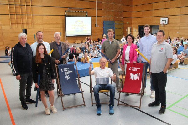 Friedhelm Susok (Mitte, sitzend) stimmt die Kinder und die Erwachsenen auf den Energieunterricht ein. Passend dazu hat er eine Solarzelle dabei. Mit dabei (von links) Thomas Grundmann (Schulleiter der Grundschule Knetterheide), Gina Wattenberg (Stadtwerke Lemgo), Tobias Priß (Kreis Lippe), Jürgen Georgi (Umweltstiftung Lippe), Stefan Schöbel (Blomberger Versorgungsbetriebe), Eva Ellminger (Stadtwerke Detmold), Moritz Sibma (Stadtwerke Bad Salzuflen) und Michael Makosch (Stadtwerke Oerlinghausen). - © Kreis Lippe