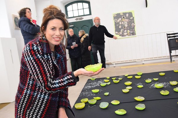 Künstlerin Alexandra Knie zeigt zum zweiten Mal Arbeiten im Ausstellungsraum der Alten Synagoge. Ihre Installation lädt dazu ein, den Raum und seine Bedeutungen auf vielschichtige Weise zu erfahren und neu zu interpretieren. In der Hand hält sie eine ihrer neongelben Schalen.
Foto: Karin Prignitz - © Karin Prignitz