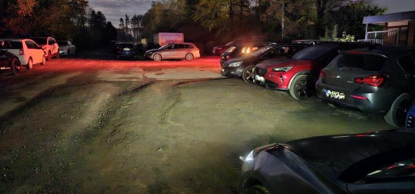 Eigentlich ist es hier stockduster. Bei der durch Autoscheinwerfer beleuchteten Szenerie hat die Kamera ein wahres Wunder bei der Bildaufhellung vollbracht. Hinter dem silbernen Kombi ist der geschotterte Bereich zu sehen, auf dem Baumaterialien gelagert werden. - © Jost Wolf