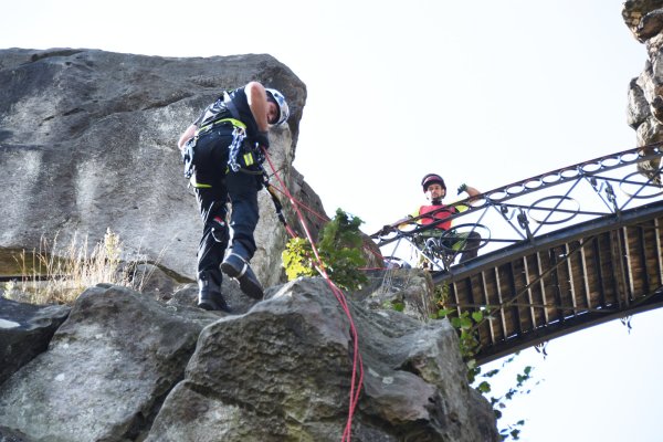 Höhenkletterer Axel Diekmann (links) seilt sich von der Brücke aus ab, um in den Felsspalten der Externsteine nach Plastikflaschen und Müll Ausschau zu halten. Sein Kollege Ulf Hornauer überblickt die Lage von oben. - © Raphael Bartling