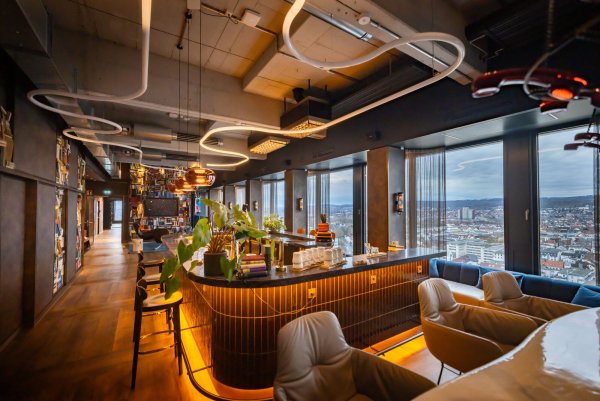 Spektakulärer Blick über Bielefeld, außergewöhliche Innenausstattung: Die Bar mit Loungebereich ist Mittelpunkt des großen Veranstaltungsbereichs in der 17. Etage des sanierten H1-Hochhauses. - © Sarah Jonek