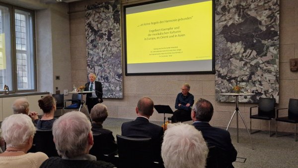 Prof. Dr. Detlef Haberland (links) sprach vor den Zuhörern im Lemgoer Rathaussaal, während Ulrich Wedemeier zwischendurch an der Laute spielte. - © Nadine Uphoff