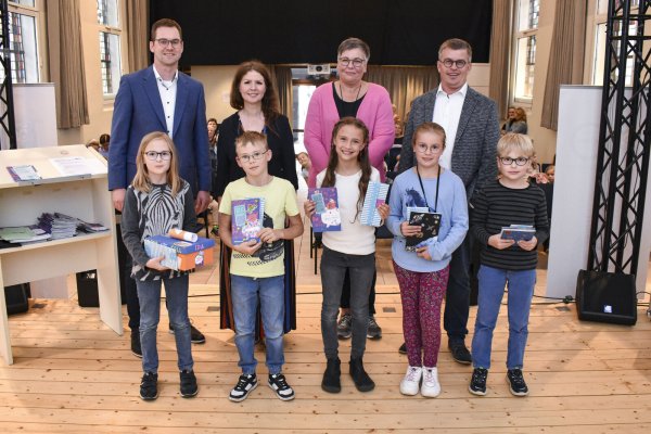 Matthias Kalkreuter (hintere Reihe, von links), Eva-Maria Allert, Silke Schwanke und Michael Biermann freuen sich mit den Gewinnern des Sommerleseclubs (vordere Reihe, von links) Ida Wilkens, Ben Schuh, Hermine Wegener, Amelie Martens und Elia Wilkens. Es fehlt Hannah Heitländer. - © Marcel Mompour