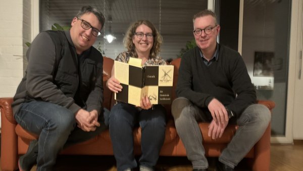 Henrik (von links) und Birgit van Gellekom sowie Christian Puls mit einer Chronik Lockhausens. - © Sven Kienscherf
