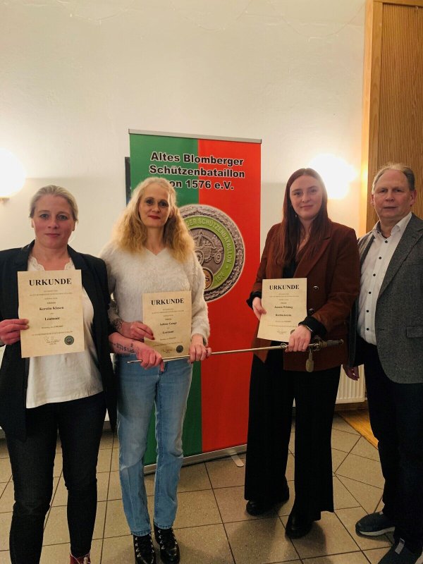 Kerstin Klasen, Sabine Gange und Jasmin Whiting (von links) schreiben Geschichte. Sie sind verantwortlich für das erste Frauenrot im Alten Blomberger Schützenbataillon. Oberst Peter Begemann (rechts) gratuliert. - © ABS