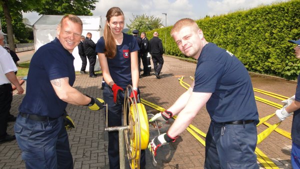 Mit vereinten Kräften wickelt das Horn-Bad Meinberger Trio den Schlauch auf, der zuvor zum Löschangriff eingesetzt wurde: (von links) Hauptfeuerwehrmann Maik Kalous, Unterbrandmeisterin Rebecca Hennemann und Unterbrandmeister Nils Hammelmann. - © Hajo Gärtner