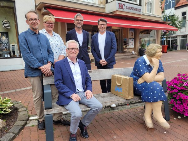 Thomas Voss hat neben der französischen Dame Platz genommen, hinter ihm stehen (von links) Thorsten Pohle, Iris Riekehof, Ralf Hammacher und Martin Schliemann vom Verein Stadtmarketing Lage. - © Astrid Sewing