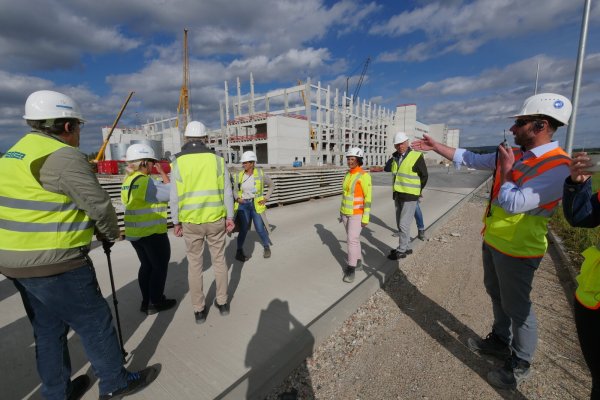 Bauleiter Tobias Amann (rechts) erklärt, dass die vorgefertigten Platten links im Hintergrund die Grundlage für die aus Beton gegossenen Zwischendecken bilden. - © Jost Wolf