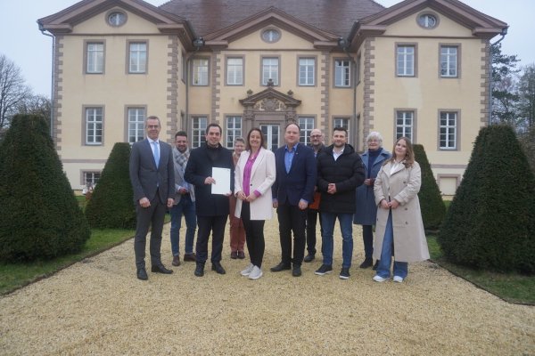 Regierungspräsidentin Anna Katharina Bölling (vorne Mitte) übergibt in Schieder den Förderbescheid an die Lokale Aktionsgruppe. Mit dabei waren Jörg Bierwirth (Bürgermeister Schieder-Schwalenberg, von links), Andre Köller (Phoenix Contact), Torben Blome (Bürgermeister Lügde), Diana Rieke (Bezirksregierung), Christoph Dolle (Bürgermeister Blomberg), Konstantin Plümer (Bezirksregierung), Tim Sölter (Stadt Horn-Bad Meinberg), Rita Siemer (SoLaWi) und Saskia Jäger (Regionalmanagement). - © Michaela Weiße