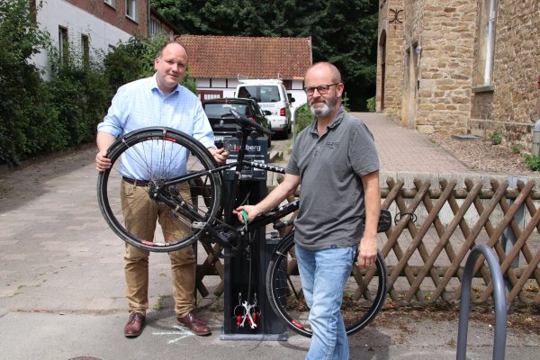 Bürgermeister Christoph Dolle und Detlef Wehrmann, Fachbereichsleiter für Bauen-und Stadtentwicklung, testen die neue Fahrradservice-Station in Donop. - © Stadt Blomberg