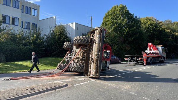 Der umgestürzte Traktor wird auf der Bielefelder Straße von einer Fachfirma wieder aufgerichtet. Die Freiwillige Feuerwehr Bad Salzuflen stellt derweil den Brandschutz sicher. - © Feuerwehr Bad Salzuflen