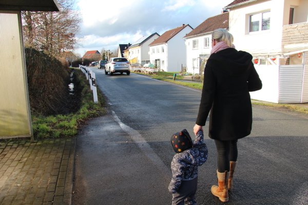 Die Birkenkampstraße ist schmal. Es gibt keinen Geh- oder Radweg für die Anlieger. Jana Strate muss mit ihrem Sohn daher aufpassen, wenn Autos vorbeifahren. - © Nadine Uphoff