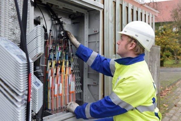Westnetz-Netzmeister Simon Prasse am Glasfaser-Verteilerschrank. Von hier werden die Glasfasern bis in die Häuser verteilt. Jedem Haus ist eines der farbigen Kabeln zugeordnet.  - © Westnetz GmbH