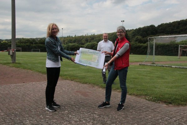 Auf dem Sportplatz in Langenholzhausen präsentieren Ute Seidemann (links) und Cornelia Rehse zusammen mit Bügermeister Mario Hecker die Pläne für den Umbau - falls die Fördermittel kommen. - © Carolin Brokmann-Förster