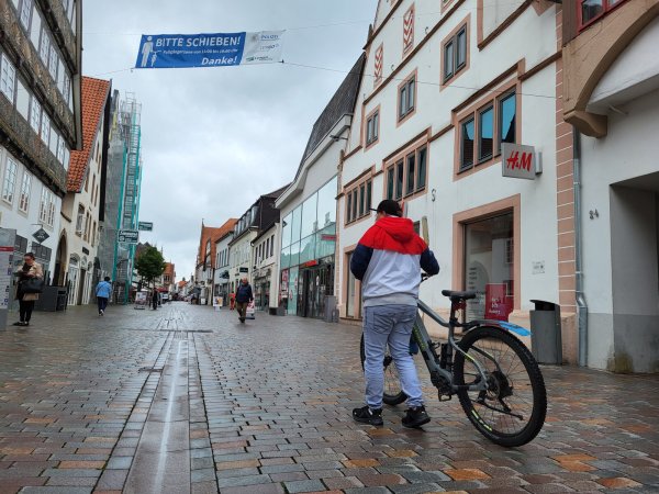Ab 11 Uhr ist in der Lemgoer Fußgängerzone das Schieben des Fahrradas angesagt. Darauf weisen auch die neuen Banner über der Einkaufsstraße hin. - © Freya Köhring