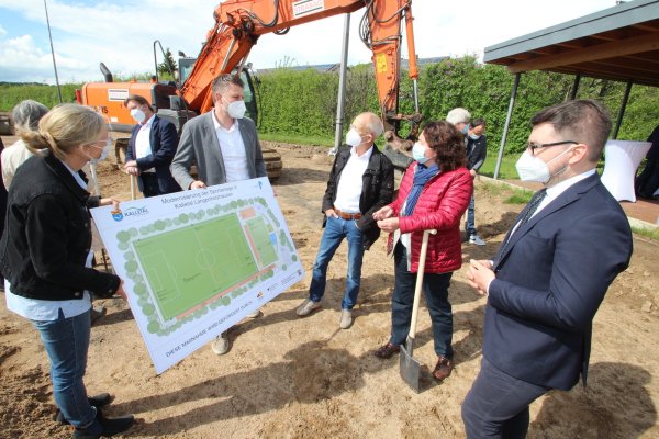 Beim ersten Spatenstich für den Kunstrasenplatz in Langenholzhausen gruppieren sich (von links) Ute Seidemann (Gemeinde Kalletal), Jonas Heidbreder (Planungsbüro Pätzold und Snowadsky), Friedhelm Böger (Kreissportbund) sowie die Bundestagsabgeordneten Kerstin Vieregge (CDU) und Christian Sauter (FDP) um einen Plan des Areals. - © Jens Rademacher