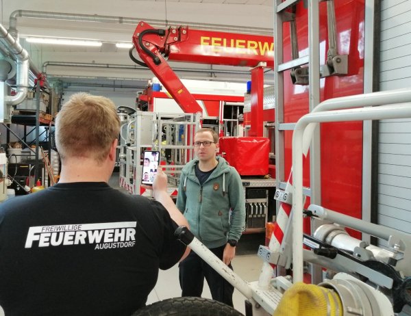 Die Augustdorfer Jugendfeuerwehr geht neue Wege. Fahrzeugkunde steht auf dem Stundenplan des ersten digitalen Dienstabends. Gemeindejugendfeuerwehrwart Christoph Diekmann (rechts) gibt die Erklärungen, während Jugendwart Carsten Hansmeier mit dem Smartphone filmt. - © Feuerwehr Augustdorf
