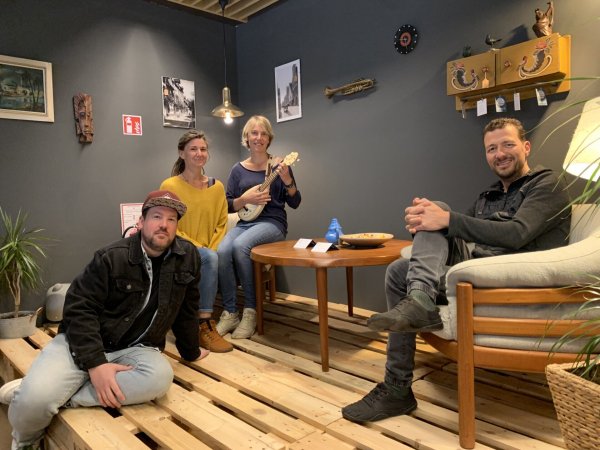 "Rümpelgold"-Mitarbeiter und Inneneinrichter Marcel Fricke (von links), das Musikerinnengespann "Duo a.mie" mit Nadine Brokmann und Anne Miebach sowie Christian Brokmann, Chef von "Rümpelgold" und "G. Rümpel", sitzen auf der Bühne im Laden an der Haferstraße in Lemgo. - © Kyrill von Matuschka