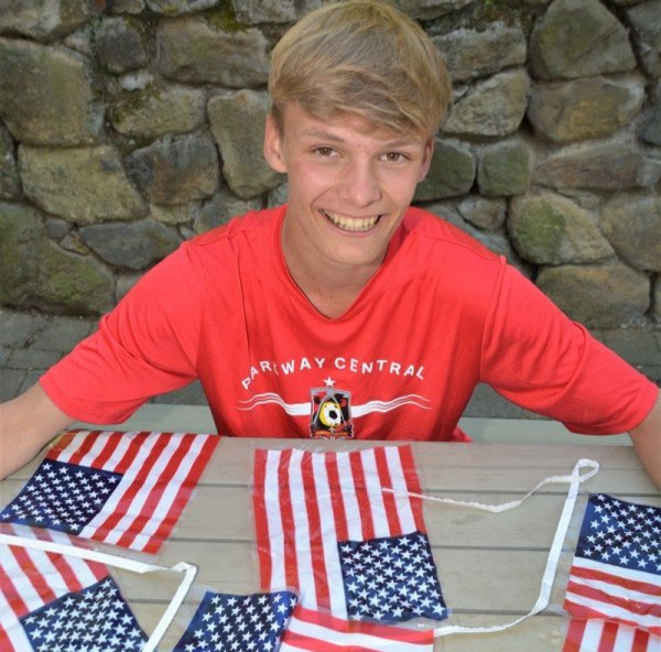 Nelson Worm (15), Schüler des Niklas-Luhmann-Gymnasiums, trägt das rote Shirt der Parkway Central Highschool. Vor ihm liegen symbolisch amerikanische Flaggen. - © Karin Prignitz