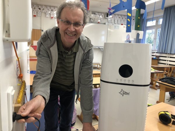 Der Hausmeister der Grundschule Kirchheide, Sebastian Bode, schließt eines der neuen Luftfilter-Geräte an. - © Till Brand