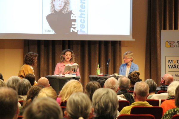 Sally Lisa Starken (Mitte) liest aus ihrem Buch. Auch die Moderatorinnen des Abends, Silke Buhrmester (links) und Claudia Biehahn, hören interessiert zu. - © Carolin Brokmann-Förster