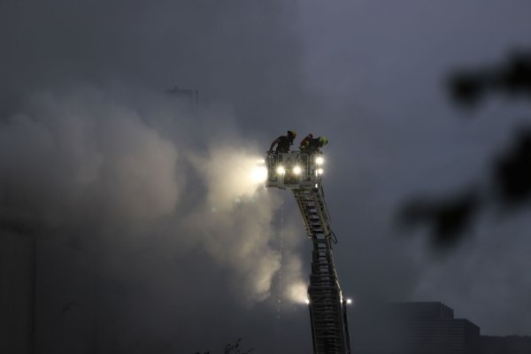 Über eine Drehleiter kämpfen Feuerwehrleute an der Sperrmüll-Halle gegen den Brand. - © Sascha Thelen/dpa