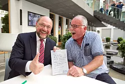 Zupackende M&auml;nner: Anton Renneke (r.) und Martin Schulz sind jetzt Genossen. Einige Leser fotografieren die Szenerie von weitem. - &copy; Oliver Krato