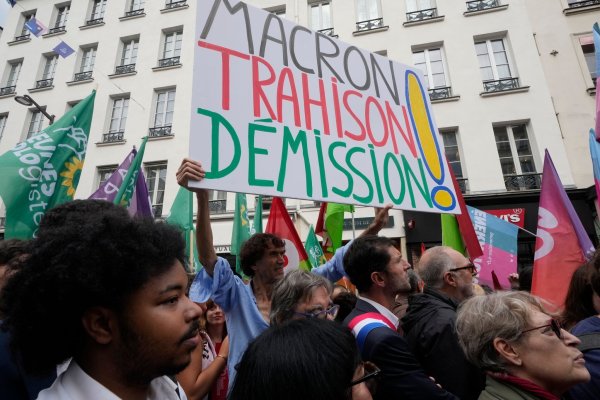 «Rücktritt von Macron - Verrat» wird auf einem Plakat auf einer Demonstration in Paris gefordert. - © Michel Euler/AP/dpa