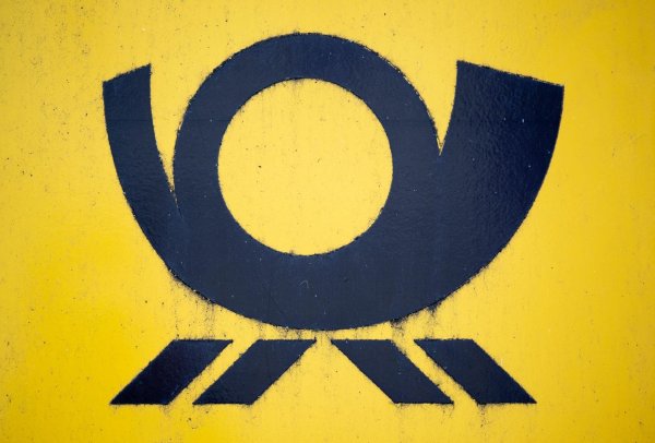 Blick auf einen Briefkasten der Deutschen Post, auf dem das Posthorn-Logo zu sehen ist. - © Hendrik Schmidt/dpa