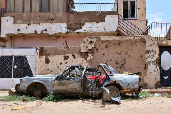 Ein zerstörtes Auto steht im sudanesischen Omdurman vor einem Haus voller Einschüsse. (Archivbild) - © Mudathir Hameed/dpa