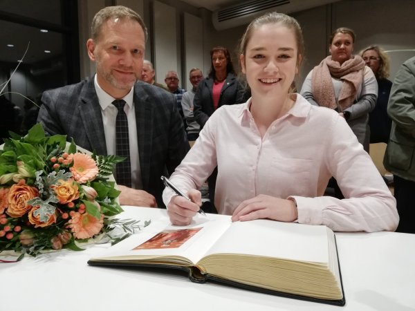 Antonia Synold darf sich in das goldene Buch der Stadt Barntrup eintragen. Sie ist Weltmeisterin im Rollkunstauf. - © Carolin Brokmann-Förster