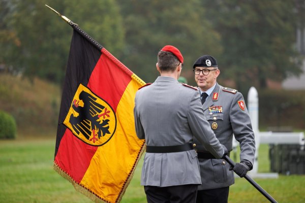 Brigadegeneral Marco Eggert (r) übergibt eine Deutsche Fahne beim Feierlichen Appell für das neu aufgestellte Artilleriebataillon 215 in der General-Feldmarschall-Rommel-Kaserne. - © Friso Gentsch/dpa