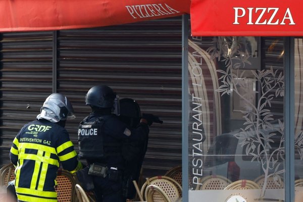 Polizisten stehen vor dem Restaurant in Issy-les-Moulineaux. - © Ian Langsdon/AFP/dpa