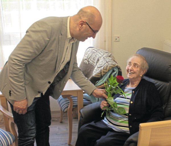 Einrichtungsleiter Oliver Höche überreicht Bewohnerin Helga Bruns eine Rose zur Begrüßung. Die 86-Jährige fühlt sich schon richtig wohl in ihren neuen vier Wänden. - © Michaela Weisse