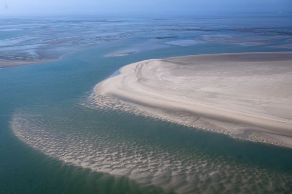 Die Sandbänke zwischen den ostfriesischen Inseln aus der Luft. Der Klimawandel hat Folgen für das Ökosystem im Wattenmeer. - © Sina Schuldt/dpa