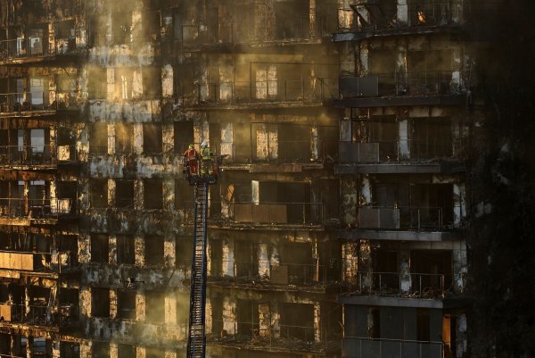 Feuerwehrleute stehen während Löscharbeiten auf einer Hubleiter. - © Alberto Saiz/AP/dpa