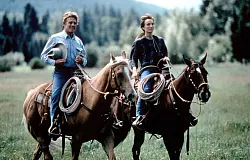 Eine Szene aus "Der Pferdefl&uuml;sterer": Tom (Robert Redford) und Annie (Kristin Scott Thomas) reiten gemeinsam aus. - &copy; picture alliance / obs