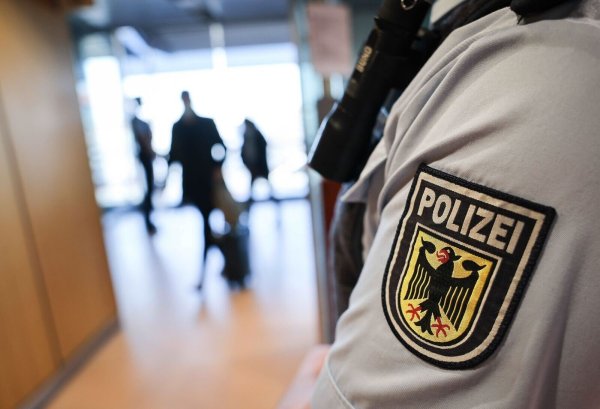 Ein Beamter der Bundespolizei kontrolliert Reisende am Flughafen. - © Christian Charisius/dpa/Symbolbild