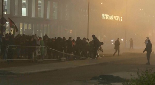 In diesem Videostandbild werfen pro-palästinensische Demonstranten eine Metallbarriere in der Nähe des Fußballstadions in Amsterdam um. (Archiv) - © RTL Nieuws/RTL Nieuws/AP/dpa