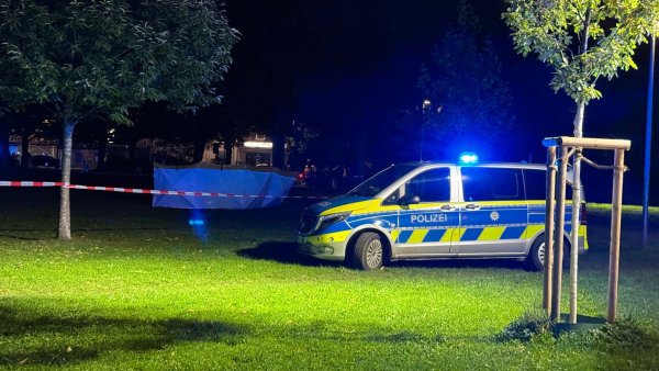 Ein Polizeiauto steht neben einer Absperrung im Lutherpark in Witten. - © Justin Brosch/dpa