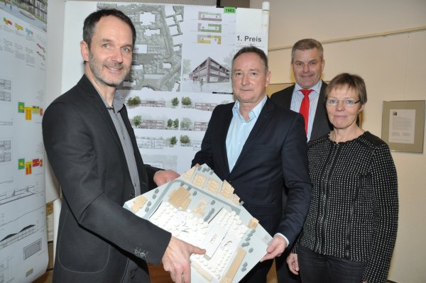 Die Sieger: Professor André Habermann (links) und sein Partner Christian Decker (Zweiter von links) von „h.s.d. architekten" aus Lemgo zeigen ihren Entwurf. Auf der Stellwand im Hintergrund sind weitere Details zu sehen. Bürgermeister Dirk Becker und Gudrun Walter vom Planungsbüro Drees & Huesmann präsentieren die Preisträger. - © Karin Prignitz