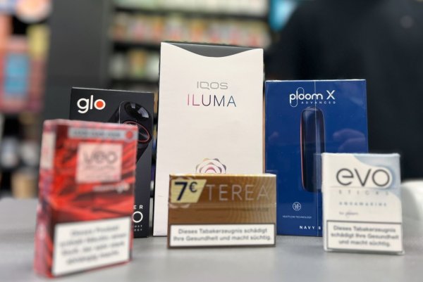 Die Tabakerhitzer-Elektrogeräte der Marken Glo von British American Tobacco (BAT), Iqos von Philip Morris und Ploom von Japan Tobacco International (JTI) mit den dazugehörigen Tabakstick-Marken liegen auf der Verkaufstheke eines Geschäfts. - © Wolf von Dewitz/dpa