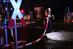 Ein Bahn&uuml;bergangsposten schaut sich nach dem Unfall in Gestringen das Flatterband an. Links hinter dem Posten ist die rote Handleuchte zu sehen, um die es in der von der Untersuchungsstelle angesprochenen Regelung geht.ARCHIVfoto: Nico Buchholz - &copy; Neue Westfaelische Zeitung