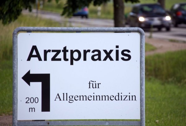 Ein Hinweisschild auf die Arztpraxis eines Allgemeinmediziners. - © DPA